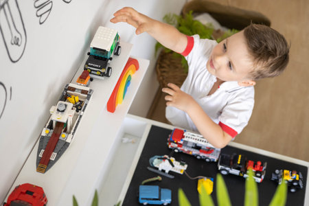 Khabarovsk, Russia, August 02, 2022. Male kid constructing toy cars and planes use Lego Classicのeditorial素材