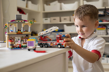Khabarovsk, Russia, August 02, 2022. Male kid constructing toy cars, fire engine and use Lego Classicのeditorial素材