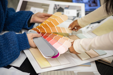 Khabarovsk, Russia, Desember 16, 2021. Customer and female interior designer coordinate color palette for indoor decor, choosing materialsの写真素材