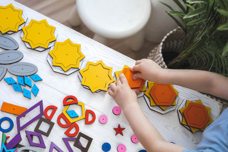 Confident baby boy assembling geometric pattern shape connecting details childish early developmentの写真素材