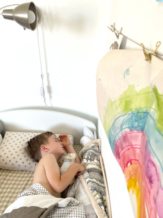 Little sweet cute baby sleeps in his bed with a toy.
