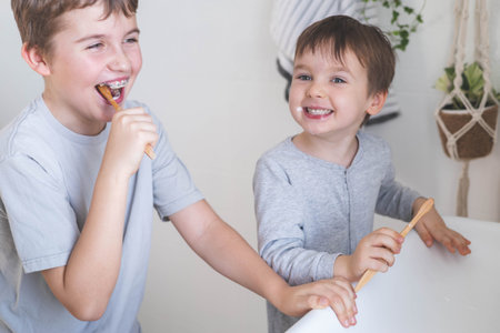 Brother morning fun male kids cleaning teeth toothbrush in front of mirror sink at bathroomの写真素材