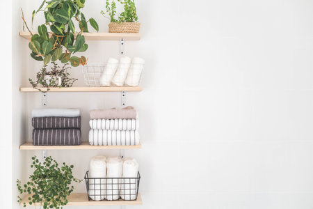 Towels roll neatly folded metallic basket arrangement wooden shelves minimal bathroom interiorの写真素材