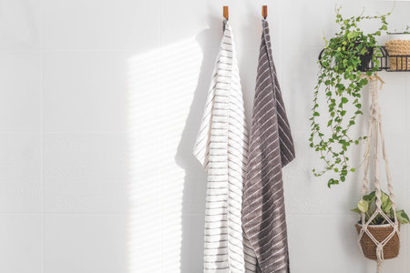 Family towels hanging sunny light white bathroom wall spa shower hygiene fabric textileの写真素材