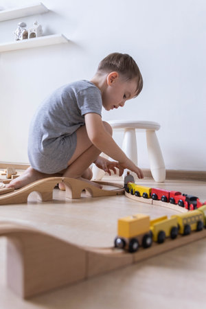 Preschool baby boy playing wooden Montessori materials rainbow arch railways at childish roomの写真素材
