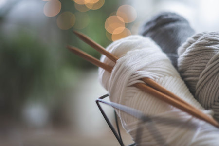 Cozy homely atmosphere. Female hobby knitting. Yarn in neutral shades in a black iron wire basket.