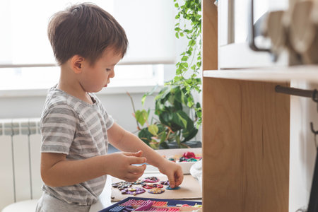 Baby boy creating plasticine diy figure with decorate dried beans element early development top viewの写真素材