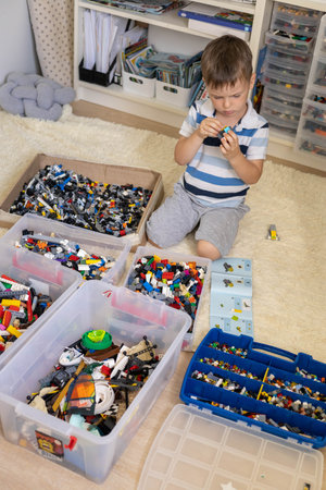 Khabarovsk, Russia, August 05, 2022. Male kid constructing toy cars and use Lego Classicのeditorial素材