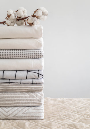Cotton branch with pile of folded bed sheets and blanketsの写真素材