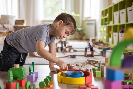Confident male kid building fortress tower architecture wooden bricks ecology Montessori materialの写真素材