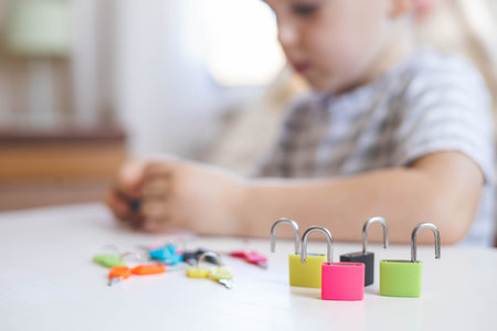 The child works with Montessori material with colored locks. Picks up keys. Develops fine motor skills.の写真素材