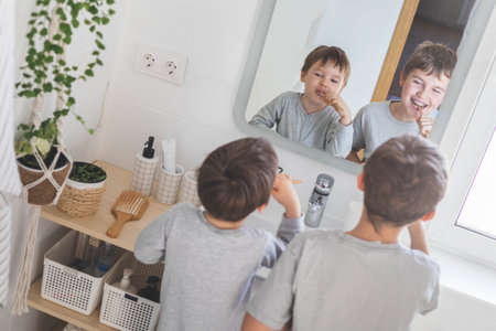 Brother morning fun male kids cleaning teeth toothbrush in front of mirror sink at bathroomの写真素材