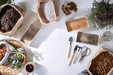 Table with fillers for houseplant transplant in boxes and paper bag gardening hobby top viewの写真素材