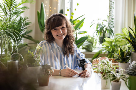 Domestic woman variegated monstera growing care writing sign plate names transplant seedlingsの写真素材