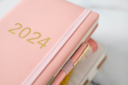 Pink coral colored diary for the year 2024, pen, marble backgroundの写真素材