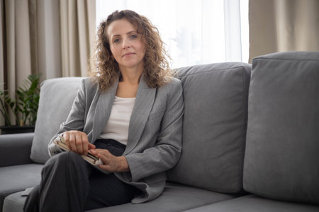 Smiling business woman psychologist relaxing enjoy break sitting on couch with notepadの写真素材