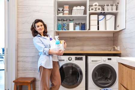 Woman housewife posing at modern white wooden bathroom laundry storage minimalism organizingの写真素材