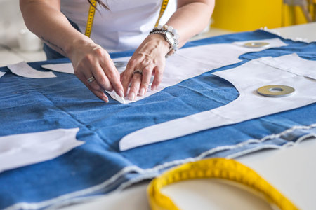 A woman dressmaker transfers the pattern and details onto the fabric. Seamstresss workplace.