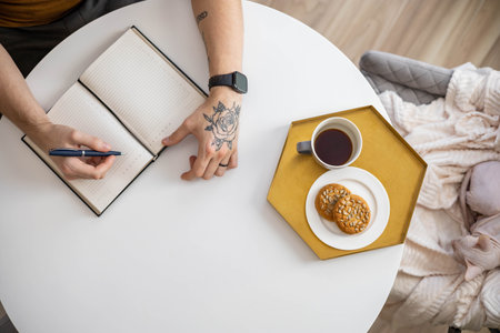 Top view of a businessman writing on a blank notepad. High angle view of a man handwriting a letterの写真素材