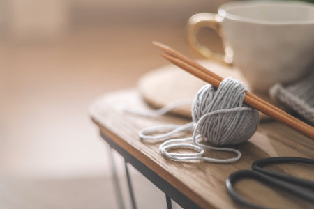 Cozy homely atmosphere. Female hobby knitting. Yarn in neutral colors in a white iron wire basket.の写真素材