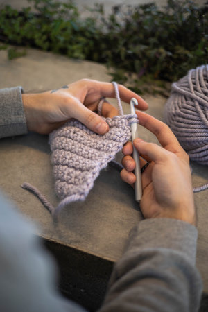 Man hands crochets handmade crocheting supplies assorted wool yarn hook knitting top view closeupの写真素材