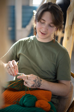 Portrait hipster man enjoy crochet handmade with crocheting supplies art hobby closeupの写真素材