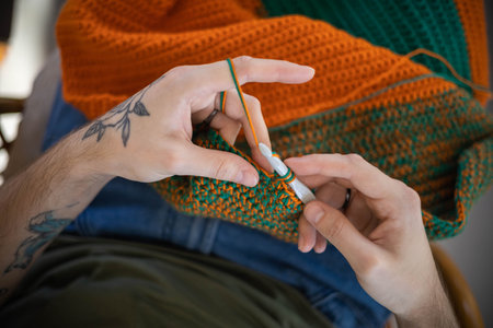 Man hands crochets handmade crocheting supplies assorted wool yarn hook knitting top view closeupの写真素材