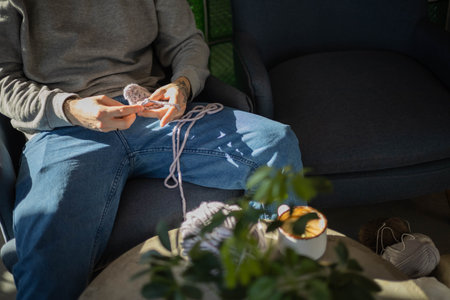 Hipster feminine male crochet handmade knitting hobby with colored yarn and hook at wooden interior
