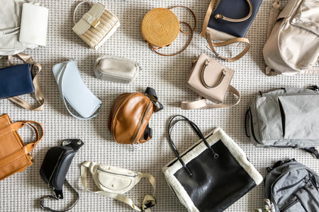 Many fashionable, stylish, trendy bags, of various sizes and shapes, are laid out on the floorの写真素材