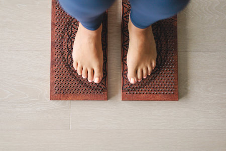 Yoga woman legs standing on nails with meditation bowl top view closeupの写真素材