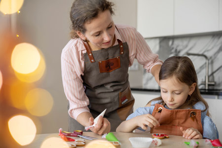 Happy family mother and daughter in aprons making Christmas cookies together while cookingの写真素材