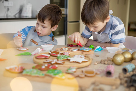 Happy family mother and children in aprons making Christmas cookies together while cookingの写真素材