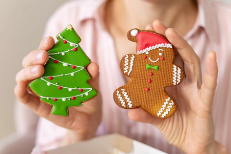 A woman holding Christmas gingerbread cookies in her hands. Christmas tree and gingerbread man.の写真素材