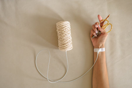 Concept of knitting, women's hobby and leisure. A woman's hand is connected with a wire to a skein.