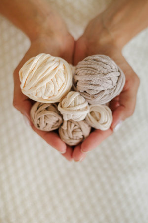 Womens hands hold balls of cotton yarn.の写真素材