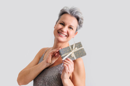 Beautiful happy middle-aged elderly woman with gray short hair smiling and looking at cameraの写真素材