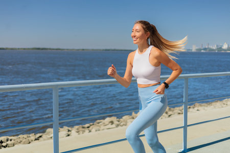 Sport woman morning running jogging on city river embankment side view