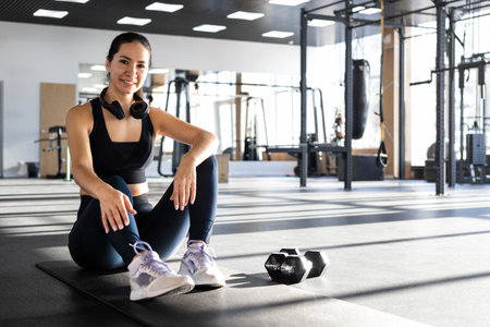 Fitness asian woman legs sitting on sport mat training with dumbbells closeup top view.
