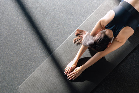 Sporty fitness woman stretching body in gym, enjoying physical activity.