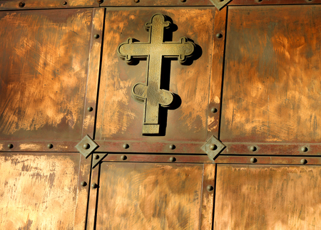 The copper cross on the gate, photographed close upの写真素材