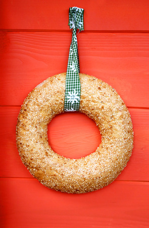 A beautiful round bread on a red background photographed in close-up