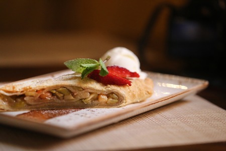 Photo of delicious apple strudel and ice cream in a cafeの写真素材