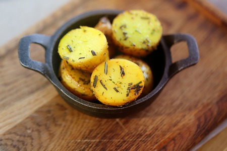 Delicious potatoes in the village with greens in iron utensils photographed close-upの写真素材