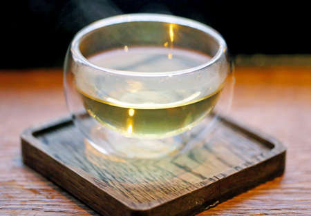 Olive oil in a small dish on a wooden stand with a close-up photoの写真素材