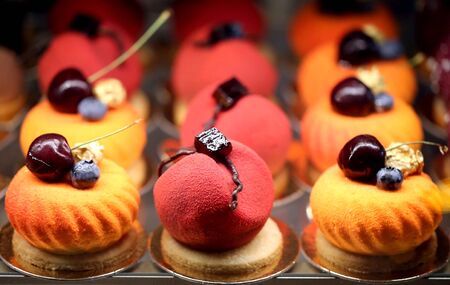 Delicious multi-colored cakes with cherries photographed close-up