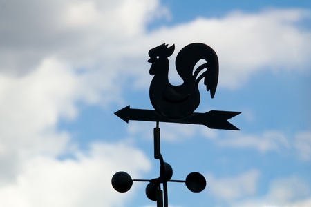 Weather vane on a backgrounds a cloudy sky の写真素材