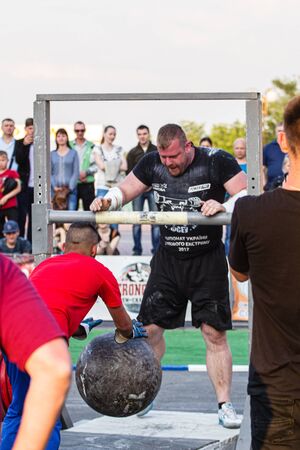 Melitopol, Ukraine, date May 27, 2017, Strongman throws a heavy ball of stone through the crossbarのeditorial素材