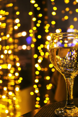 glass on table with yellow lights in the backgroundの写真素材