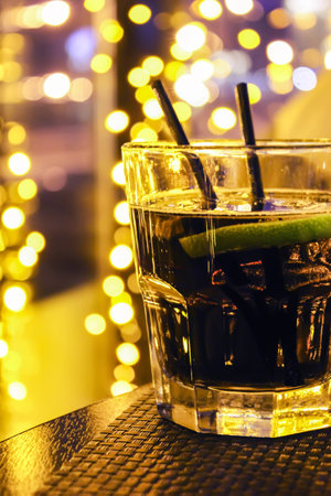 glass on table with yellow lights in the backgroundの写真素材