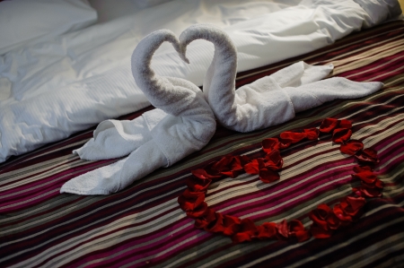 Bed with heart and swans made of towelsの写真素材